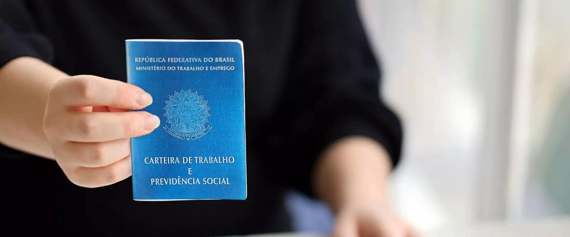 Pessoa segurando carteira de trabalho (CVTPS), representando a busca por uma vaga de emprego no SINE municipal de Porto Velho