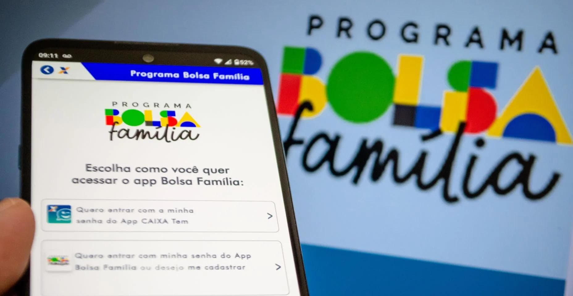 Beneficiário utiliza o celular para consultar informações do Bolsa Família, ilustrando matéria sobre o calendário de pagamentos do programa referente ao mês de julho.
